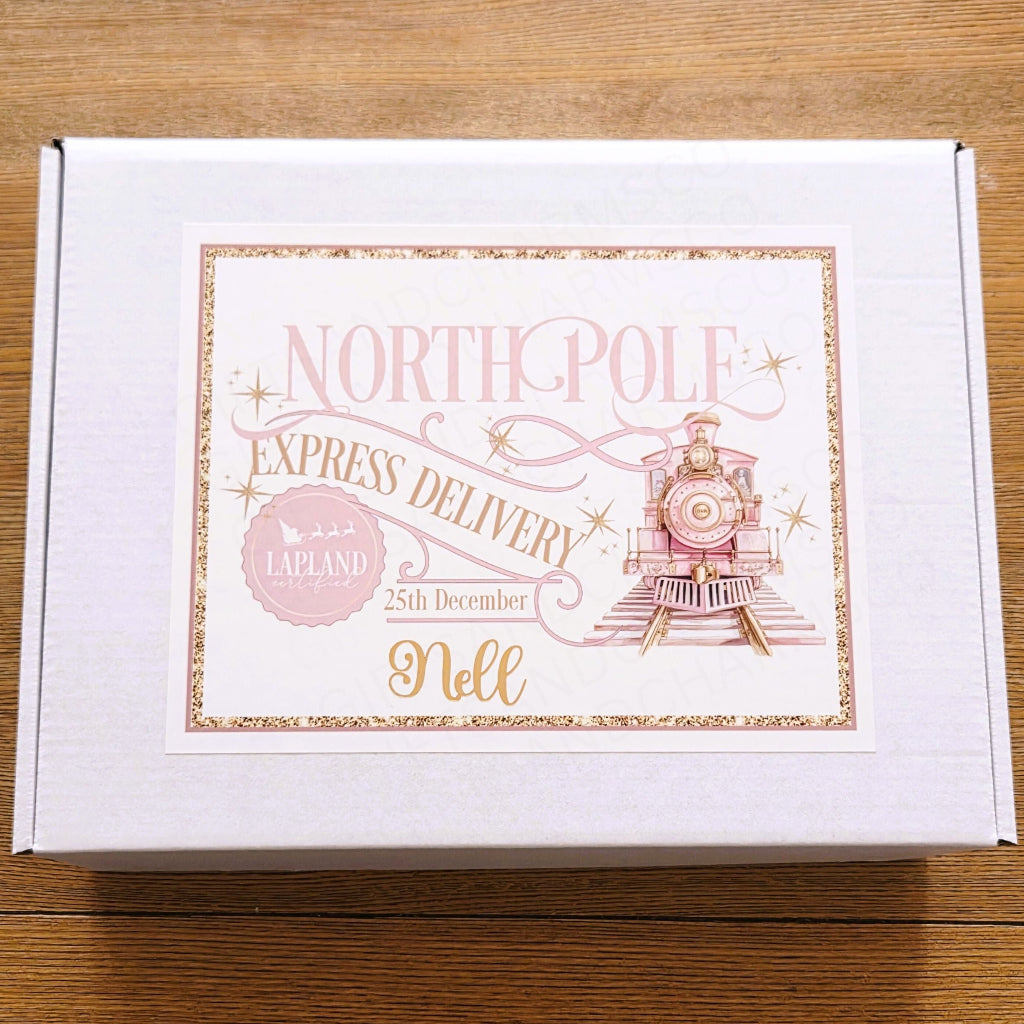 White box with 'North Pole Express Delivery' text and illustration on a wooden surface