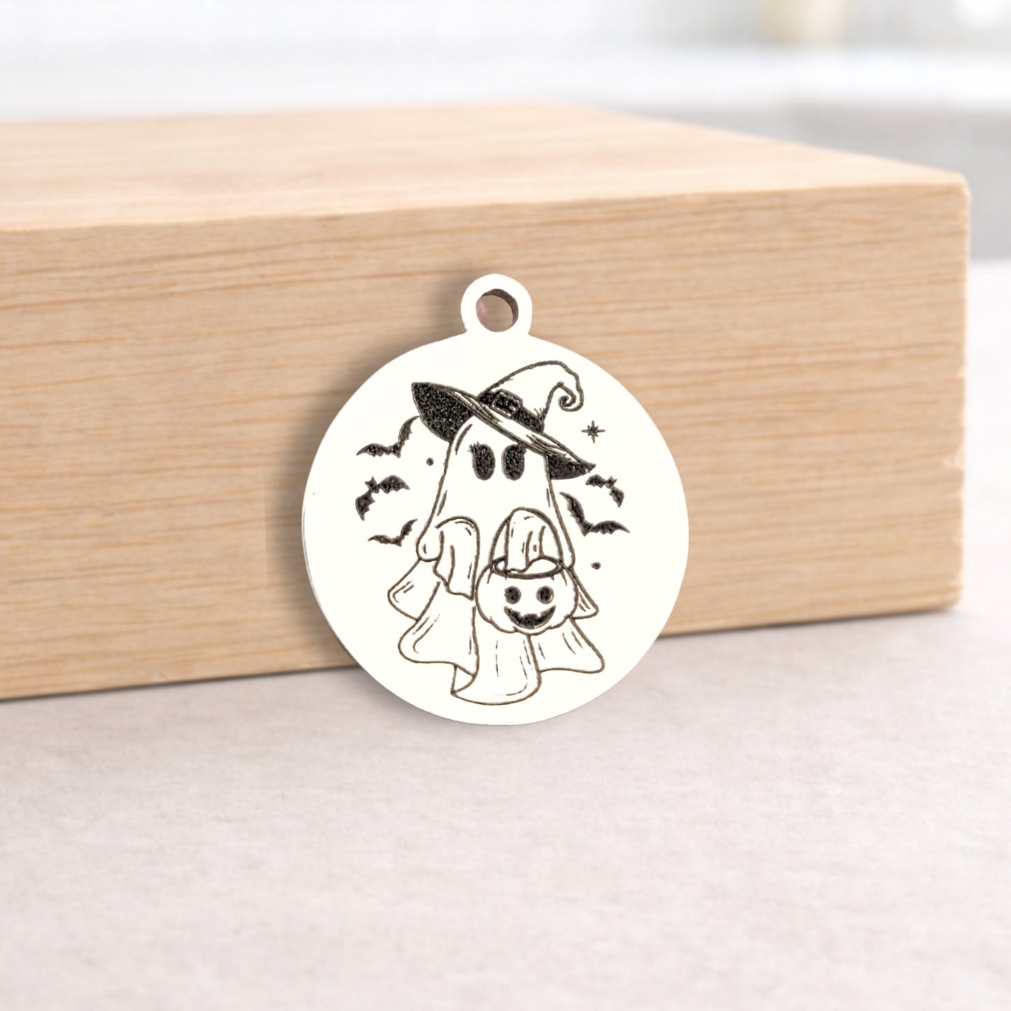 Halloween-themed metal pendant on a wooden block