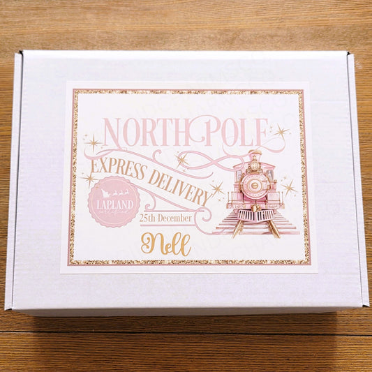 White box with 'North Pole Express Delivery' text and illustration on a wooden surface