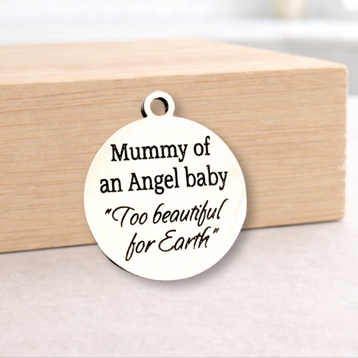 White pendant with engraved text on a wooden block