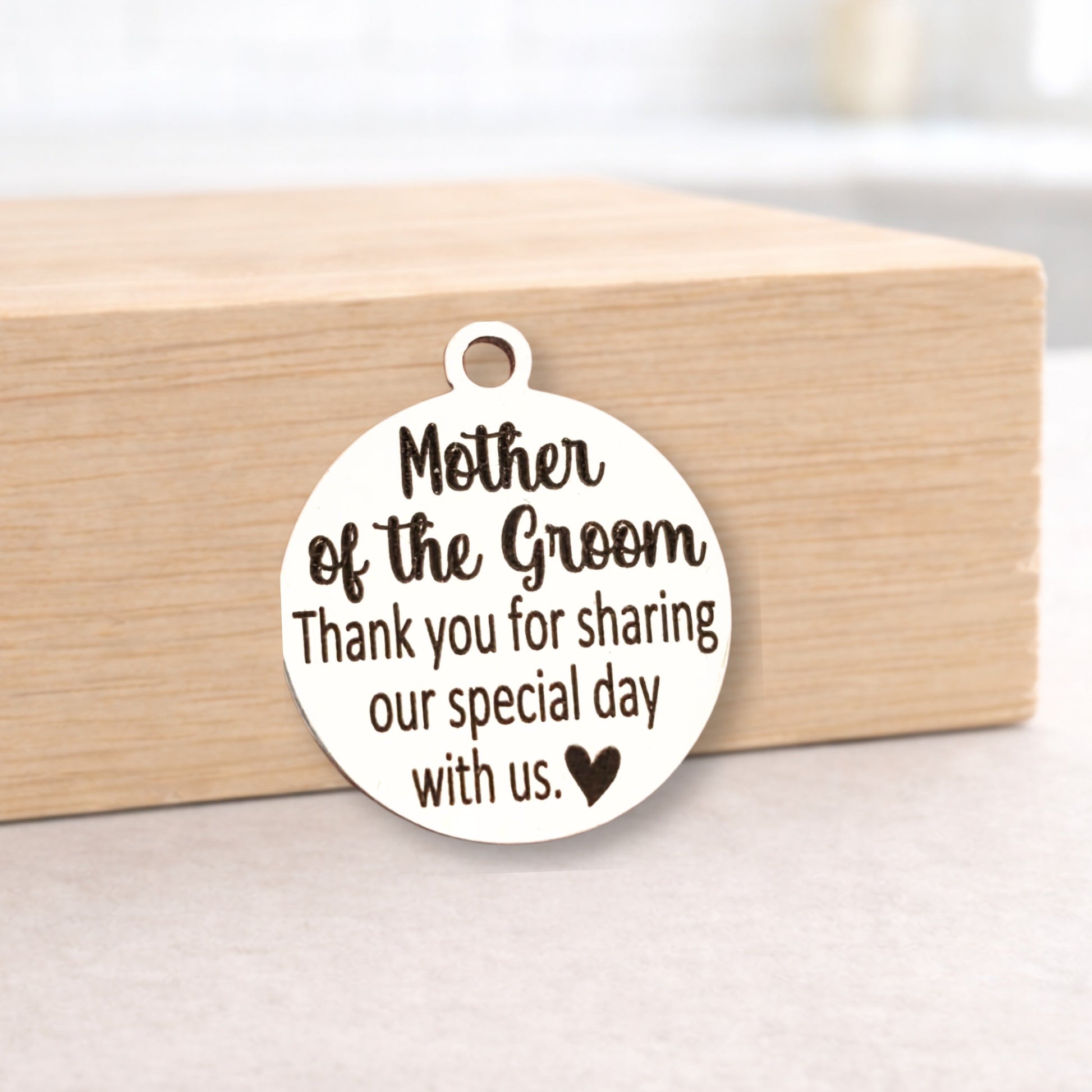 Round wooden pendant with engraved text on a wooden block