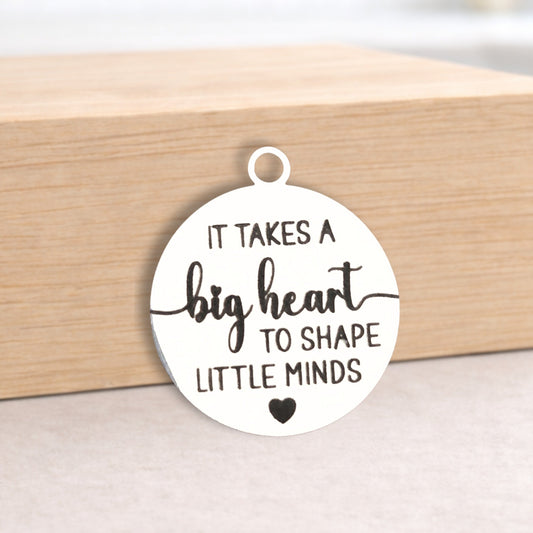 Round pendant with engraved text on a wooden block