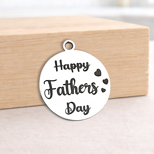 Round metal pendant with 'Happy Fathers Day' text on a wooden block