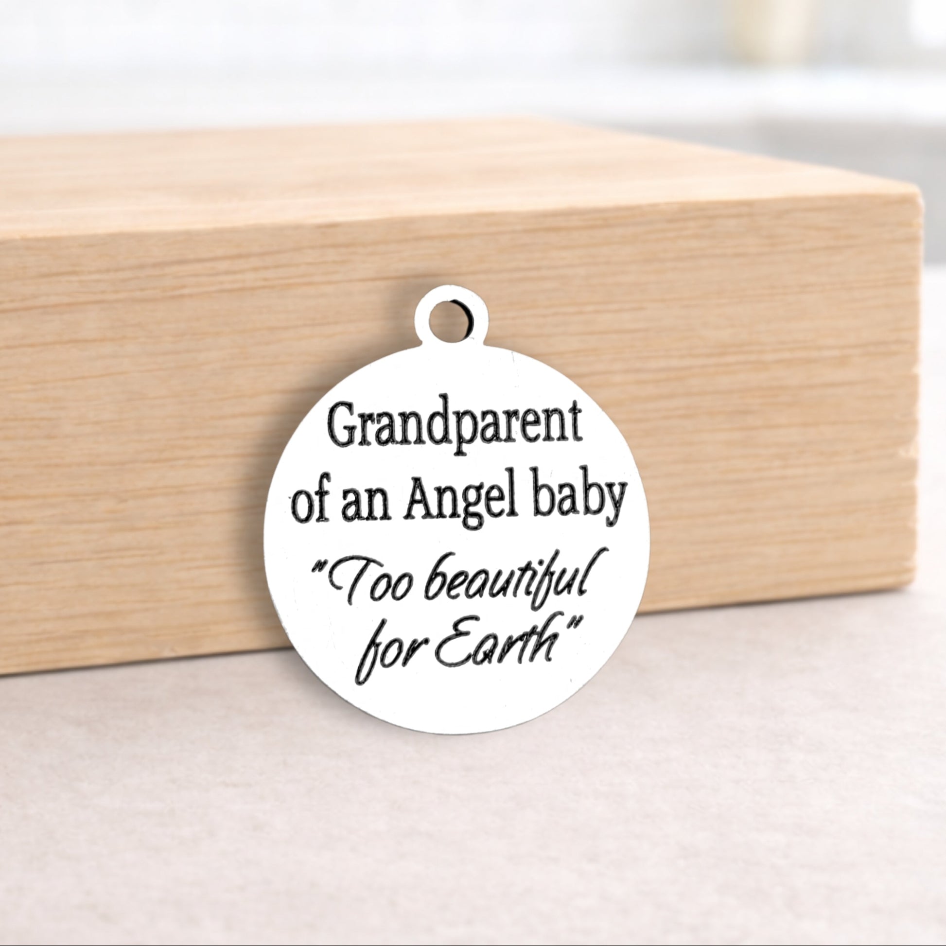 Round white pendant with text on a wooden block