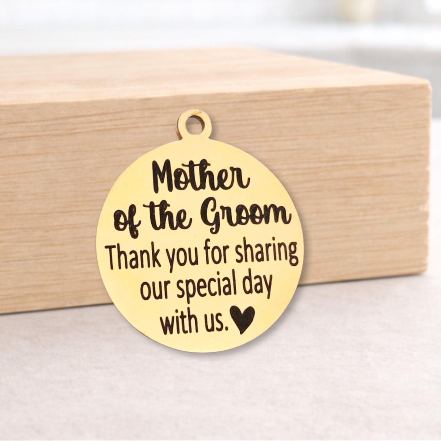 Gold pendant with engraved message on a wooden block