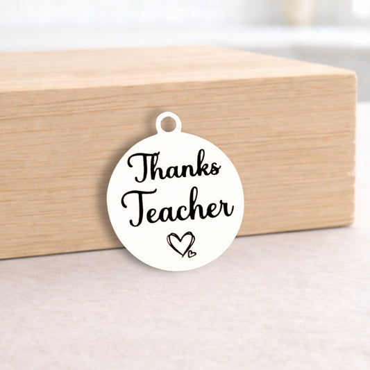 Round white pendant with 'Thanks Teacher' text on a wooden block