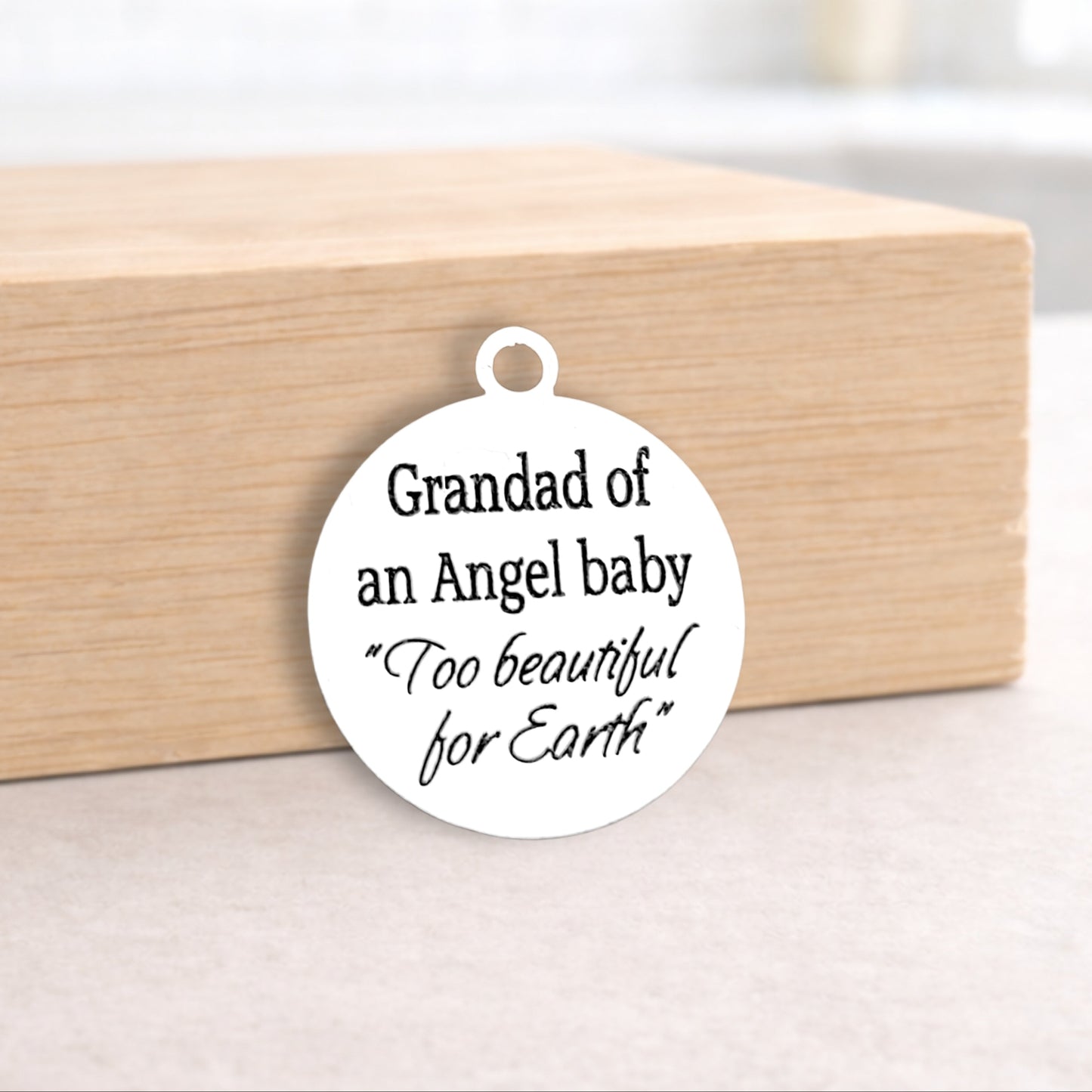 Round white pendant with text on a wooden block