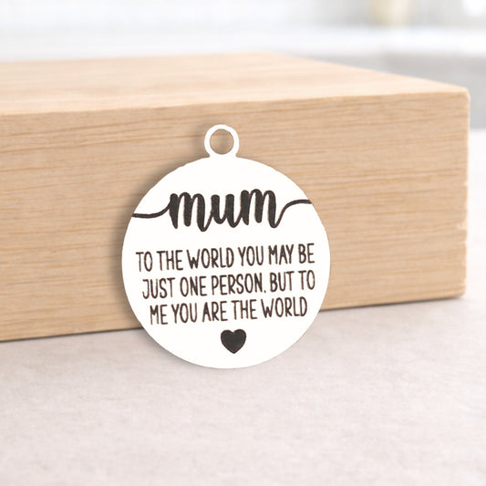 Circular pendant with engraved message on a wooden block