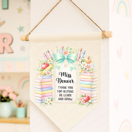 Personalized teacher appreciation banner with colorful design and text, hanging on a wall.
