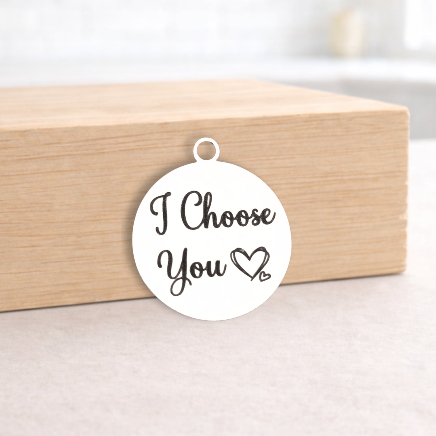White pendant with 'I Choose You' text on a wooden box