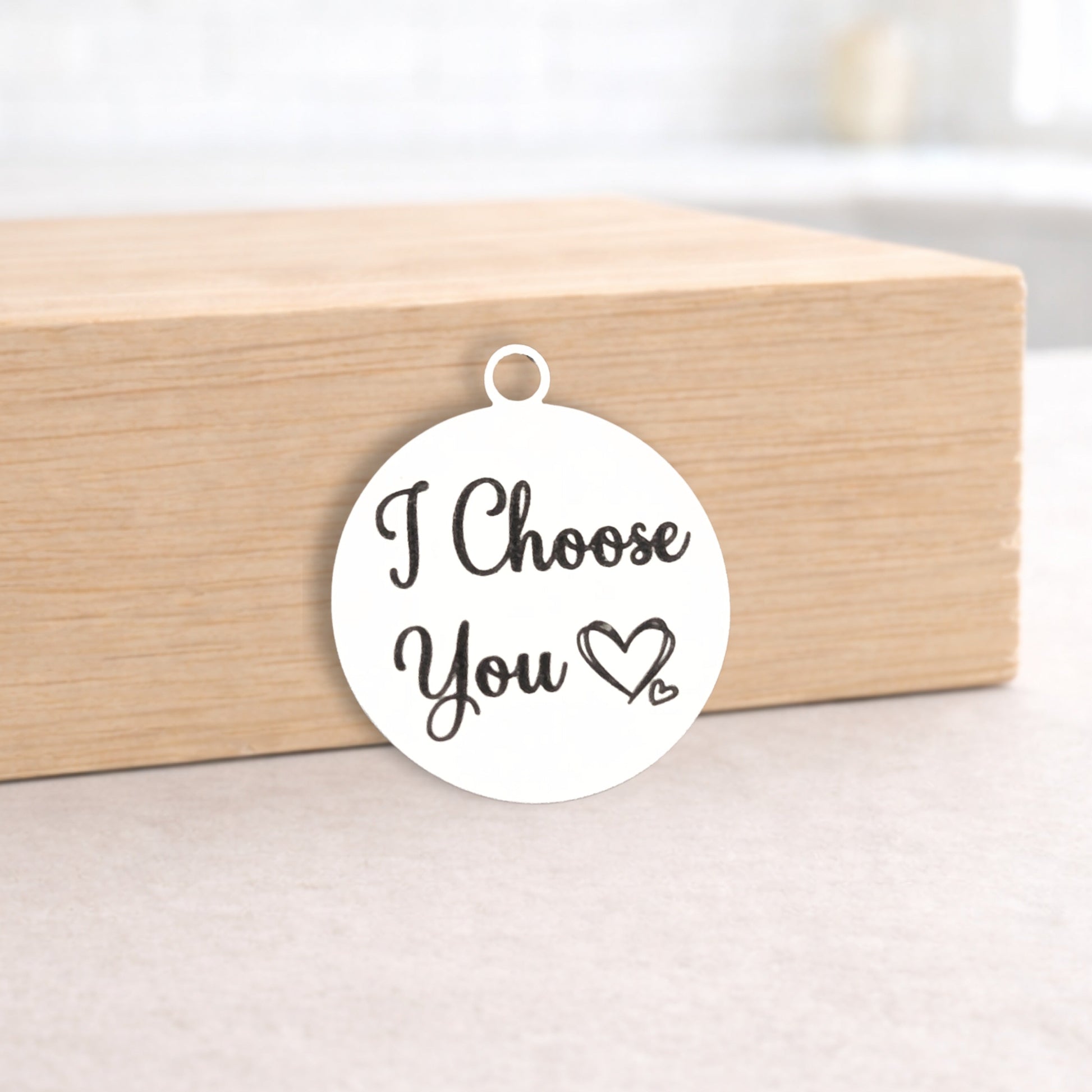 White pendant with 'I Choose You' text on a wooden box
