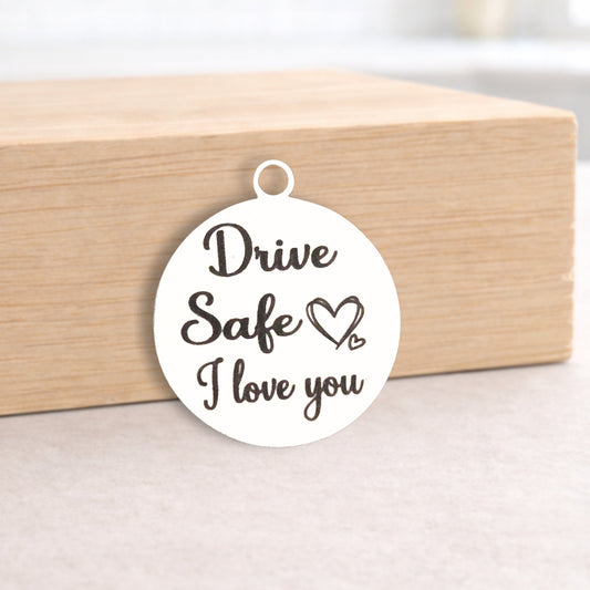 Round pendant with 'Drive Safe I love you' text on a wooden block