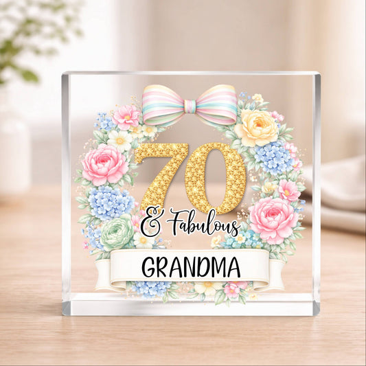 Decorative acrylic block with floral design, number 70, and text '70 & Fabulous Grandma' on a wooden surface.