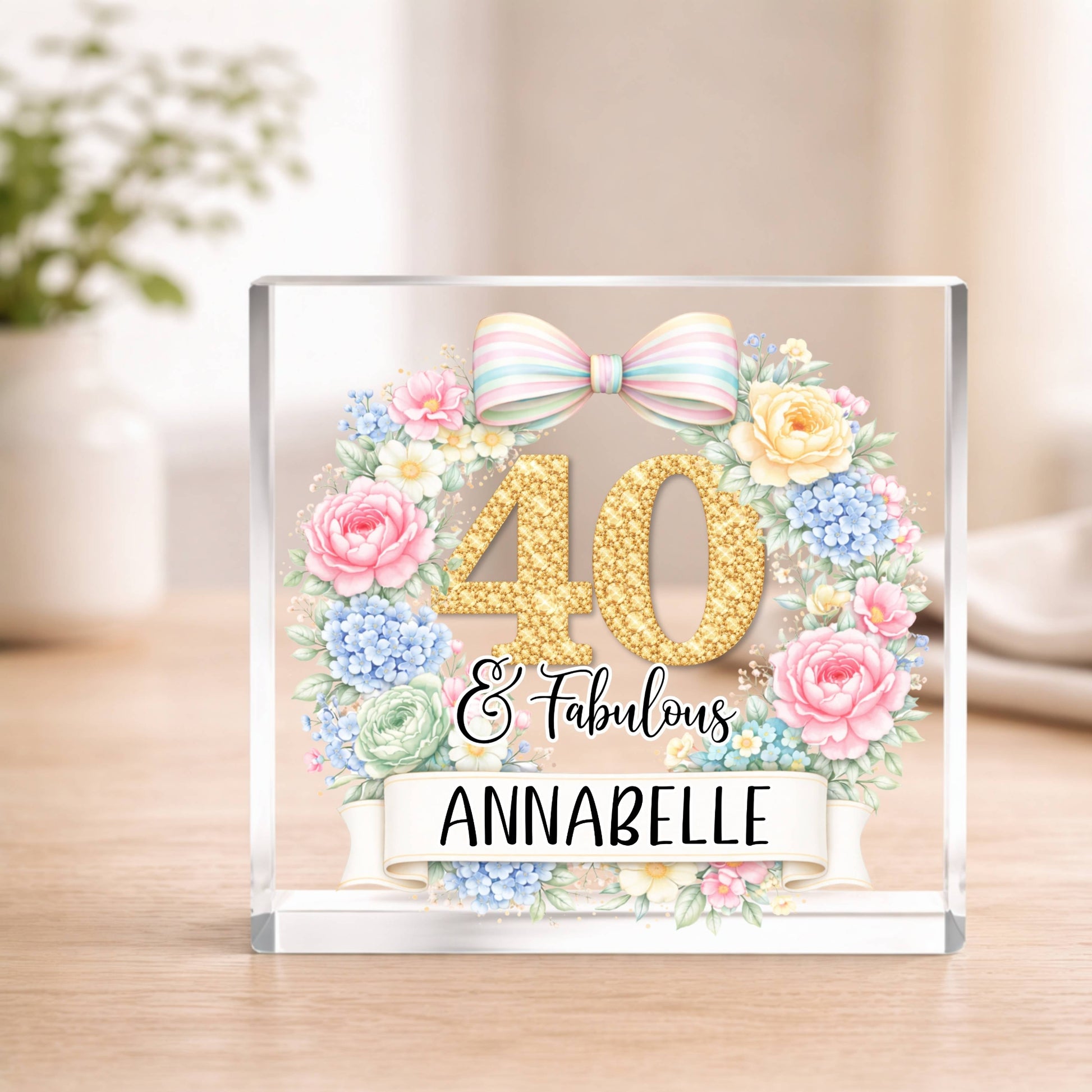 Decorative acrylic block with floral design, number '40', and text '40 & Fabulous Annabelle' on a wooden surface.