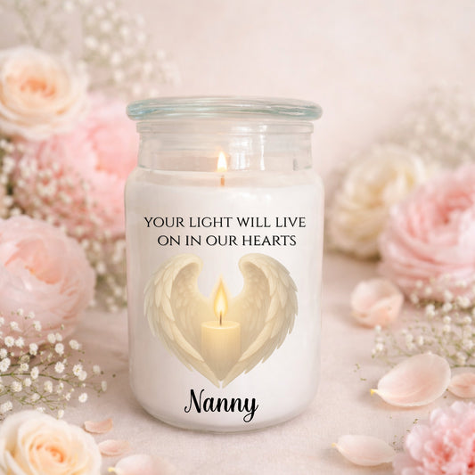 Candle in a jar with 'Your light will live on in our hearts Nanny' text, surrounded by flowers.