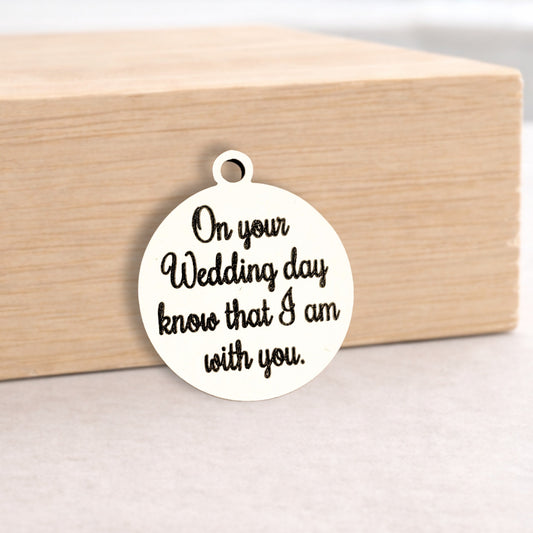 Round metal pendant with engraved text on a wooden block