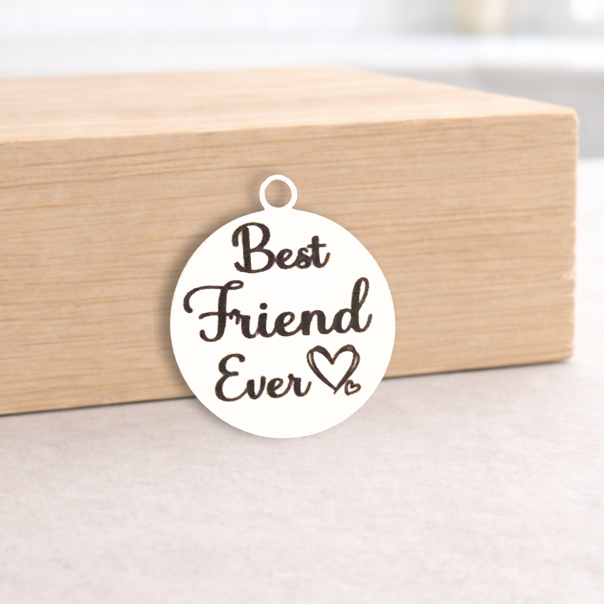 Round pendant with 'Best Friend Ever' text on a wooden block