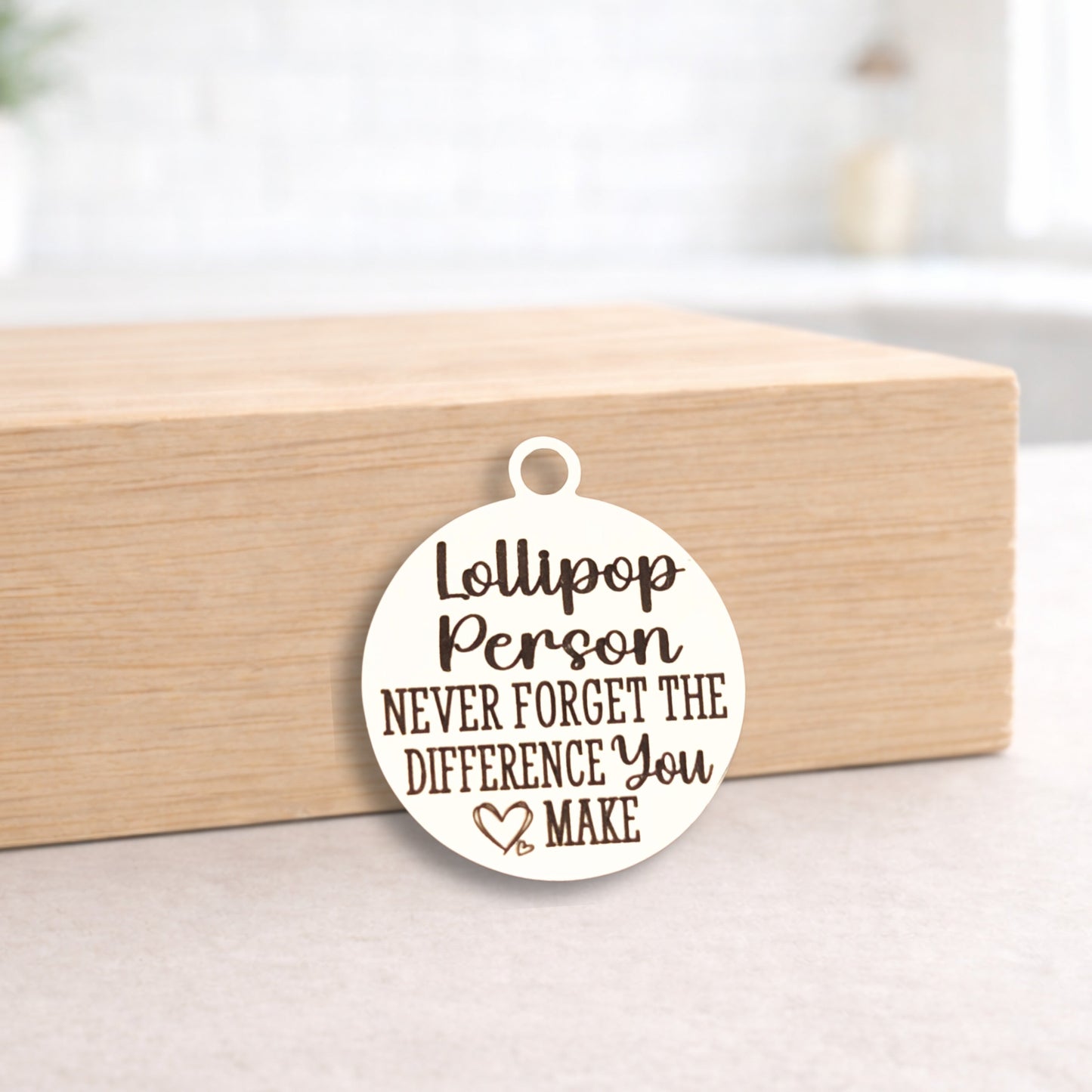 Round pendant with engraved text on a wooden block
